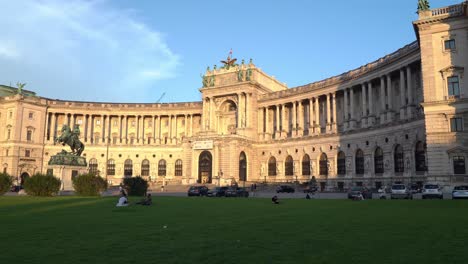 Light-Shines-on-The-Hofburg-palace-Façade-with-People-Enjoying-Warm-Weather