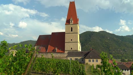 Church-of-old-town-of-Weisskirchen,-in-the-Wachau-region-of-Austria-with-Vineyard-surrouding-Building