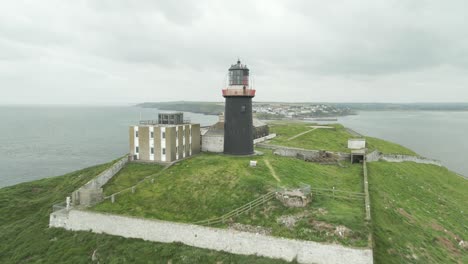 Drone-Passes-By-The-Ballycotton-Lighthouse-On-A-Cloudy-Day-In-County-Cork,-Ireland