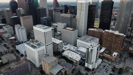 Aerial-view-rising-backwards,-revealing-the-skyline-of-Houston,-sunset-in-Texas,-USA