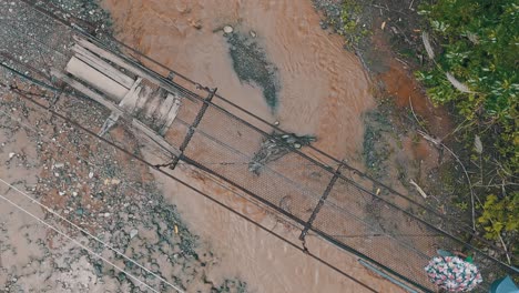 Residencia-Rural-Cruzando-Un-Viejo-Puente-Temporal-Oxidado-Sobre-El-Río-Inundado-Durante-La-Lluvia