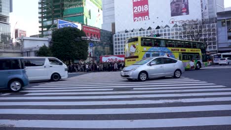 Traffic-in-Shibuya-Crossing,-while-pedestrians-wait-for-green-light,-POV---Tokyo,-Japan