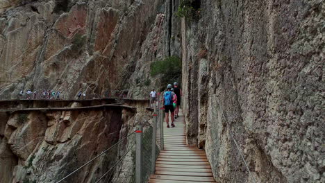 Slow-motion-shot-of-tourists-walking-along-mountain-cliff-in-ornithological-observatory-el-Cabrito-in-Tafira,-Spain-at-daytime