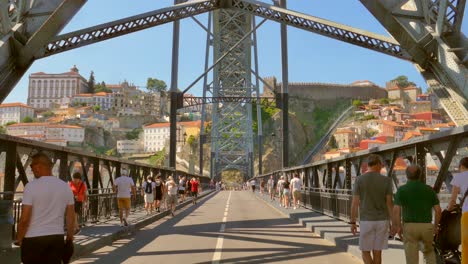 Día-Soleado-Con-Truristas-Caminando-Sobre-El-Puente-Dom-Luis-I-En-Porto,-Portugal