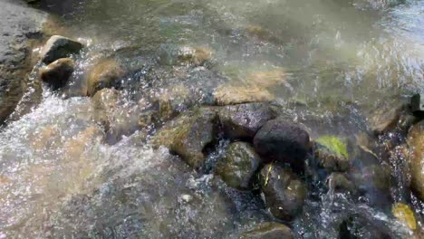 Clear-stream-running-through-stone-boulders-Abundant-river-flowing-on-stone-bottom