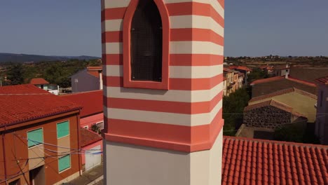 Aerial-rising-of-TresNuraghes-colorful-orange-church,-Sardinia-landscape-reveal