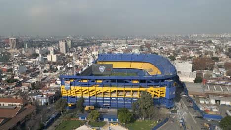 Vista-Aérea-Panorámica-Del-Icónico-Estadio-De-Fútbol-La-Bombonera-Y-Del-Barrio-Bajo-Un-Cielo-Gris-Y-Brumoso-Debido-Al-Cambio-Climático-Y-El-Calentamiento-Global,-Buenos-Aires,-Argentina