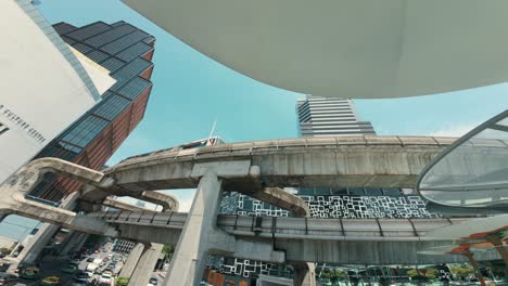 View-of-the-busy-and-bustling-life-in-Bangkok,-filled-with-cars-and-a-passing-train