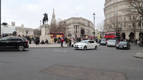 Tráfico-De-La-Ciudad-De-Londres-Con-Autobuses-Rojos-De-Dos-Pisos-Y-Protesta-En-Trafalgar-Square