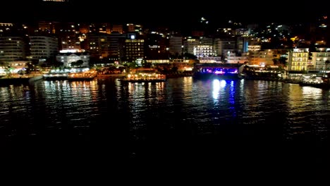 Mediterranean-Night-Charm-in-Saranda-Coastal-City's-Enchanting-Promenade-Reflecting-in-the-Serene-Bay-–-A-Tranquil-Evening-by-the-Sea
