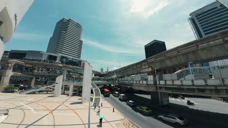 Stadtansicht-Mitten-In-Bangkok,-Mit-Autos,-Die-Durch-Die-Belebten-Straßen-Navigieren,-Umgeben-Von-Gebäuden-Und-Menschen-Zu-Fuß