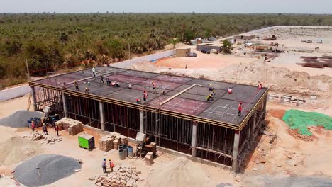 Aerial-tour-over-control-and-switch-room-of-photovoltaic-power-plant-under-construction-in-Jambur,-Gambia