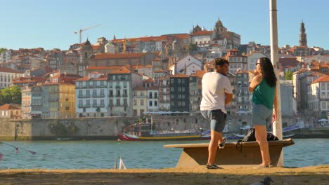 Couple-Talking-Each-Other-Near-Harbour-In-Vila-Nova-de-Gaia-During-Sunset-In-Porto,-Portugal