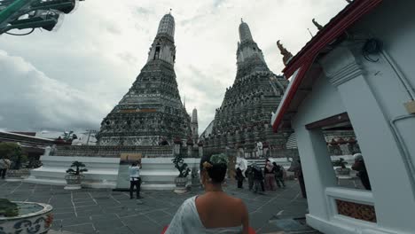 Una-Mujer-Entrando-A-Un-Sitio-Con-Dos-Pirámides-Históricas-Y-Famosas-En-Wat-Arun-De-Bangkok.