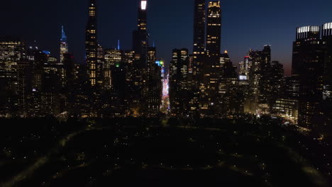 Vista-Aérea-Sobre-El-Parque-Central,-Hacia-Los-Rascacielos-Superaltos-De-La-Fila-De-Los-Multimillonarios,-Noche-En-Nueva-York,-Estados-Unidos