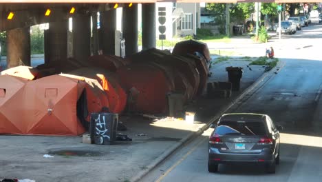 Homeless-people-sleep-in-orange-tents-under-highway-overpass-in-urban-city-in-America