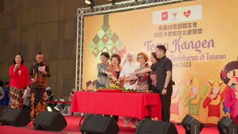 Grupo-De-Personas-Que-Participan-En-La-Ceremonia-De-Corte-De-Tumpeng-En-El-Escenario