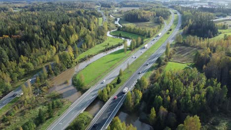 Divided-highway-and-small-river-run-through-green-city,-Kerava-Finland