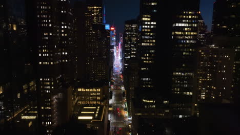 Vista-Aérea-Hacia-Atrás-Por-La-7ma-Avenida,-Lejos-Del-Times-Square,-Noche-En-Nueva-York,-Estados-Unidos