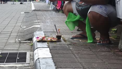 Ein-Balinesischer-Mann-Bringt-Opfergaben-Vor-Seinem-Stand-In-Tabanan,-Bali,-Indonesien