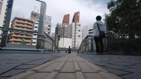 The-Nakagin-Capsule-Tower-Building-low-floor-angle-being-demolished-view-from-a-nearby-walkway-with-people-looking-at-the-tower