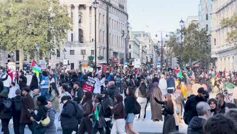 Protesting-Palestinian-Hamas-supporters-on-London-streets-walk-with-flags,-freedom-slogans-on-placards---pro-Palestinian-protest-in-UK