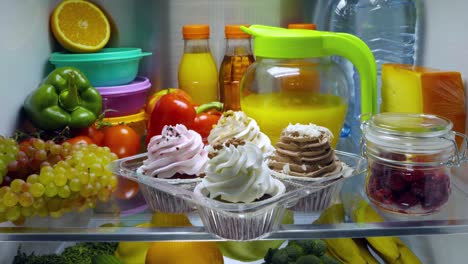 Sweet-cakes-in-the-open-refrigerator.