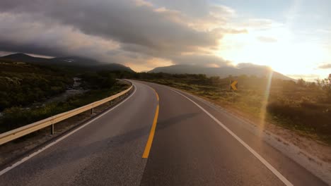 Driving-a-Car-on-a-Road-in-Norway-at-dawn