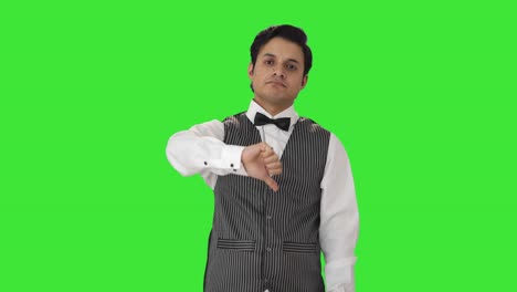 Disappointed-Indian-waiter-showing-thumbs-down-Green-screen