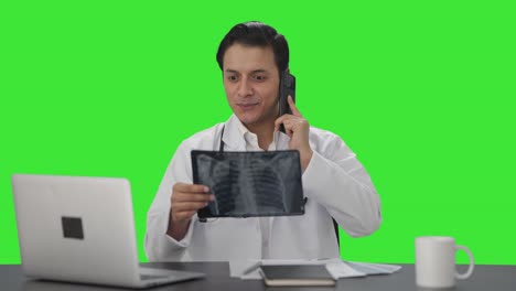Happy-Indian-doctor-explaining-X-ray-report-on-phone-Green-screen
