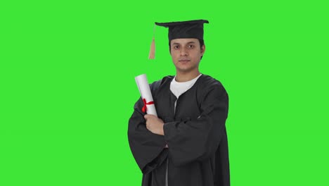 Retrato-De-Un-Estudiante-Graduado-Indio-De-Pie-Con-Las-Manos-Cruzadas-En-La-Pantalla-Verde