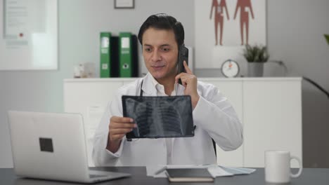 Glücklicher-Indischer-Arzt,-Der-Den-Röntgenbericht-Am-Telefon-Erklärt