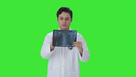 Indischer-Arzt-überprüft-Röntgenbericht-Auf-Grünem-Bildschirm