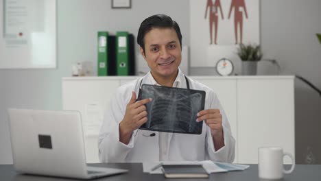 Glücklicher-Indischer-Arzt,-Der-Der-Kamera-Den-Röntgenbericht-Erklärt