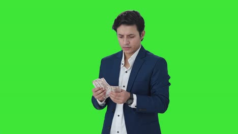 Confused-Indian-manager-counting-money-in-office-Green-screen