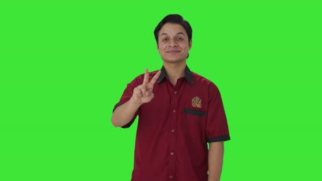 Happy-Indian-house-keeper-showing-victory-sign-Green-screen