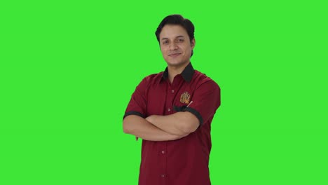 Portrait-of-happy-Indian-house-keeper-standing-crossed-hands-Green-screen