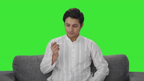 Sick-Indian-man-measuring-fever-using-thermometer-Green-screen