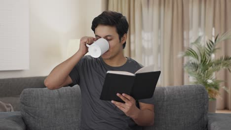 Glücklicher-Indischer-Mann,-Der-Ein-Buch-Liest-Und-Kaffee-Trinkt