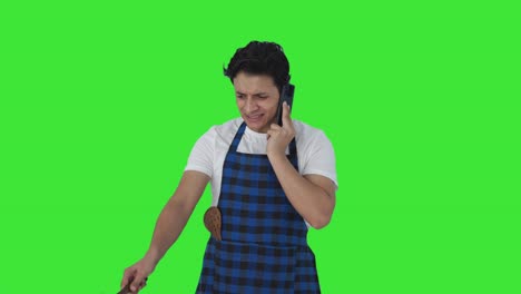 Angry-Indian-cook-making-food-while-shouting-on-phone-Green-screen