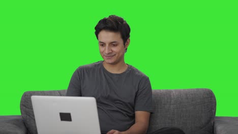 Happy-Indian-man-working-on-laptop-Green-screen