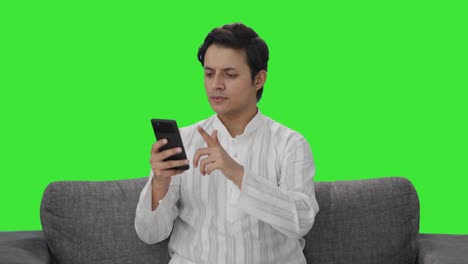 Indian-man-scrolling-through-phone-Green-screen