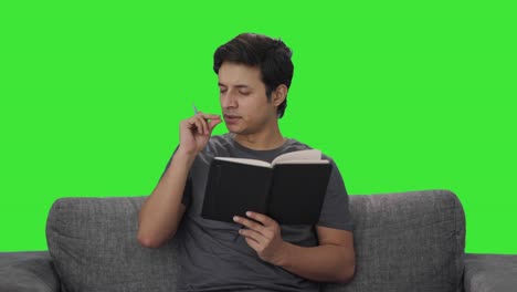 Tired-Indian-man-writing-in-diary-Green-screen