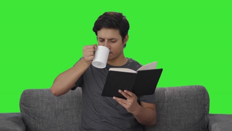 Indischer-Mann-Liest-Ein-Buch-Und-Trinkt-Kaffee-Auf-Grünem-Bildschirm