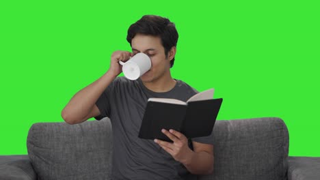 Glücklicher-Indischer-Mann,-Der-Ein-Buch-Liest-Und-Kaffee-Trinkt,-Grüner-Bildschirm