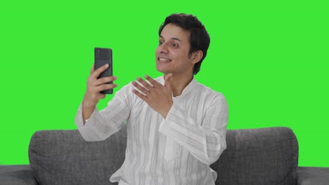 Cheerful-Indian-man-talking-on-video-call-Green-screen