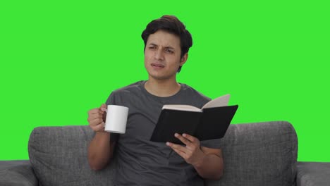 Verwirrter-Indischer-Mann,-Der-Ein-Buch-Liest-Und-Kaffee-Trinkt,-Grüner-Bildschirm