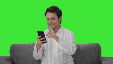 Happy-Indian-man-scrolling-phone-Green-screen