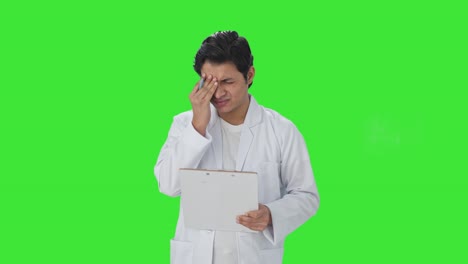 Científico-Indio-Estresado-Escribiendo-Observaciones-En-Papeles-De-Pantalla-Verde