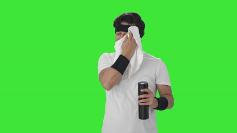 Happy-Indian-man-wiping-sweat-and-drinking-water-Green-screen